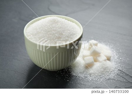 Granulated sugar in bowl on dark table Granulated sugar in bowl on dark table 140733100