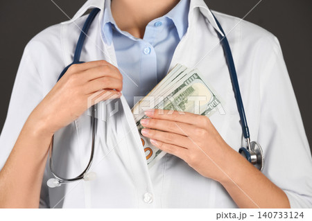 Doctor putting bribe into pocket on black background, closeup. Corruption in medicine Doctor putting bribe into pocket on black background, closeup. Corruption in medicine 140733124