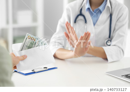 Doctor rejecting bribe in clinic, closeup. Corrupted medicine 140733127