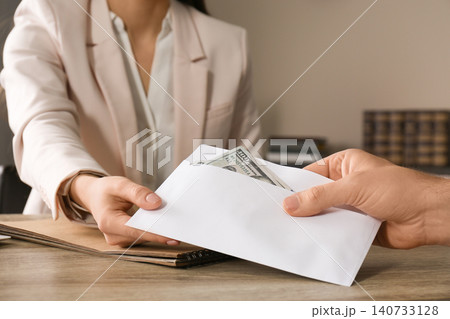 Man giving bribe to woman at table, closeup Man giving bribe to woman at table, closeup 140733128