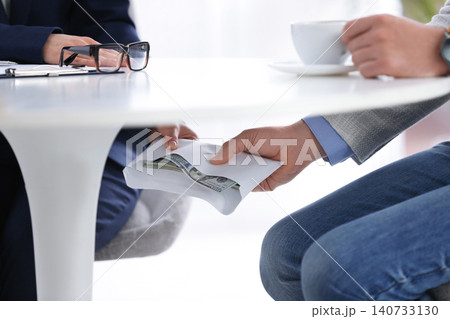 Man giving bribe to woman under table in office, closeup 140733130