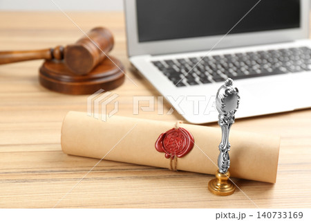 Notary's public pen and sealed document near laptop on wooden table Notary's public pen and sealed document near laptop on wooden table 140733169
