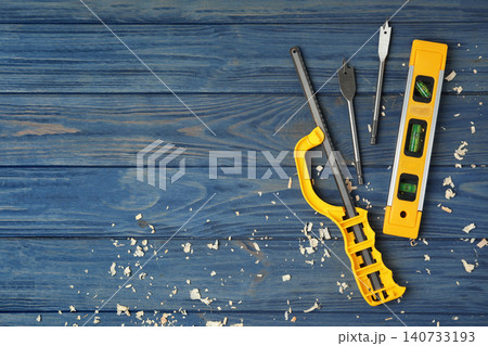 Modern carpenter's tools and shavings on blue wooden background, flat lay. Space for text Modern carpenter's tools and shavings on blue wooden background, flat lay. Space for text 140733193