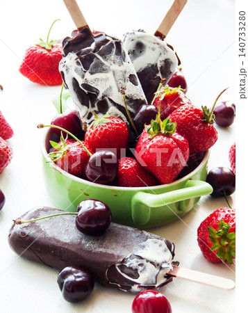 Sweet chocolate vanilla ice cream with red ripe strawberries and cherries, summer refreshing dessert Sweet chocolate vanilla ice cream with red ripe strawberries and cherries, summer refreshing dessert 140733280