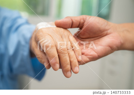 Caregiver holding hands Asian elderly woman patient, help and care in hospital. 140733333