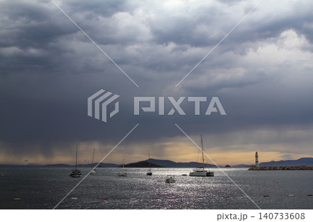 Seascape at sunshine. Lighthouse and sailings on the coast. Seaside town of Turgutreis and spectacular sunshine Seascape at sunshine. Lighthouse and sailings on the coast. Seaside town of Turgutreis and spectacular sunshine 140733608
