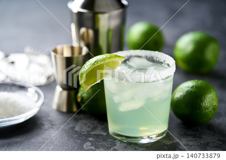 classic margarita cocktail garnished with lime and salt rim on a black table, selective focus. classic margarita cocktail garnished with lime and salt rim on a black table, selective focus. 140733879