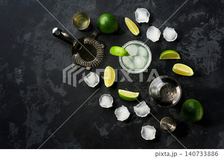 Refreshing summer alcoholic cocktail margarita with crushed ice and lime, on a black table, top view. 140733886