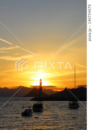 Seascape at sunshine. Lighthouse and sailings on the coast. Seaside town of Turgutreis and spectacular sunshine Seascape at sunshine. Lighthouse and sailings on the coast. Seaside town of Turgutreis and spectacular sunshine 140734079