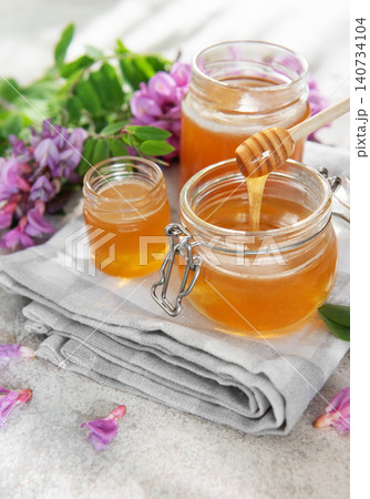 Honey in jars with dipper and acacia flowers Honey in jars with dipper and acacia flowers 140734104