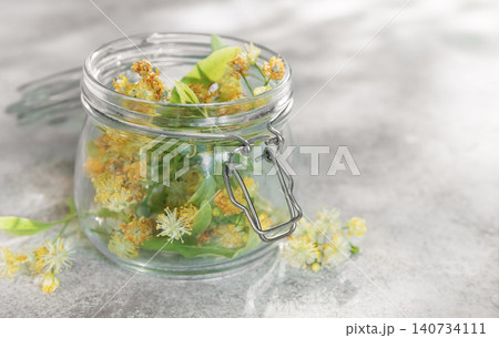 Linden blossoms filling glass jar for herbal medicine Linden blossoms filling glass jar for herbal medicine 140734111