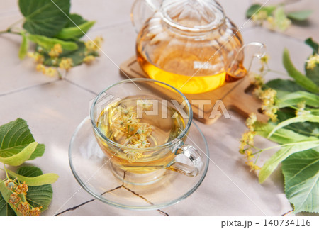 Linden flower herbal tea brewing in glass teapot Linden flower herbal tea brewing in glass teapot 140734116