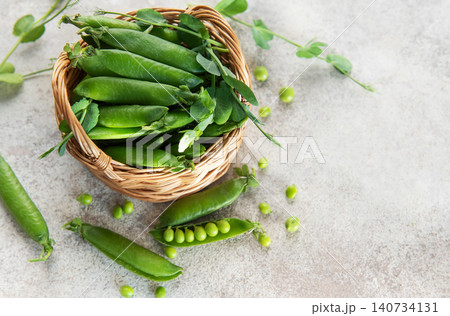 Fresh green peas pods in a wicker basket Fresh green peas pods in a wicker basket 140734131