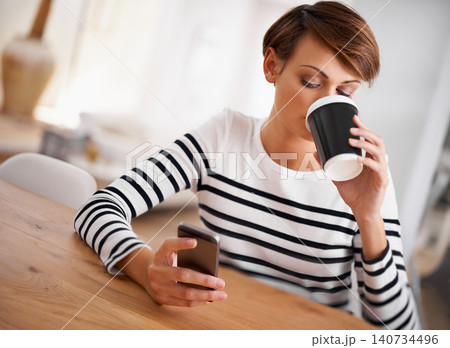 Phone, reading and woman with coffee in dining room networking on social media, mobile app or internet. Research, technology and female person with cappuccino scroll on cellphone at modern apartment. 140734496