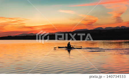 Summer sunset on the sea, man on the boat. Silhouette of man rowing on a canoe on the lake or river during colorful sunset. Copy space for text, travel photo. Recreation, leisure activity concept Summer sunset on the sea, man on the boat. Silhouette of man rowing on a canoe on the lake or river during colorful sunset. Copy space for text, travel photo. Recreation, leisure activity concept 140734533