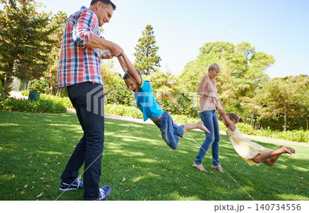 Parents, children and spinning fun in garden for bonding game together on park field for summer, recreation or connection. Mother, father and siblings with laugh on backyard grass, family or carefree Parents, children and spinning fun in garden for bonding game together on park field for summer, recreation or connection. Mother, father and siblings with laugh on backyard grass, family or carefree 140734556