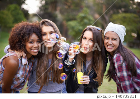 Friends, bubbles and portrait of women in nature for bonding, smile and happiness outdoors. Happy, fashion and gen z with people with soap bubble in park for weekend, holiday and vacation together Friends, bubbles and portrait of women in nature for bonding, smile and happiness outdoors. Happy, fashion and gen z with people with soap bubble in park for weekend, holiday and vacation together 140735811