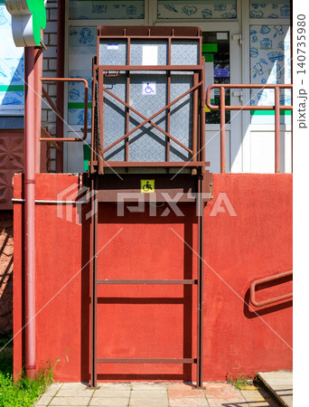 Outdoor wheelchair platform lift for disabled people near building stairs. Outdoor wheelchair platform lift for disabled people near building stairs. 140735980