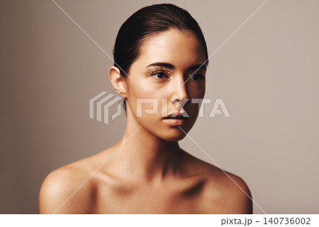 Woman, makeup and gold sparkle on eyes for beauty, cosmetology and glamour with cosmetics on beige background. Eyeshadow, glitter and fashion model in studio, art or creativity with shimmer and glow 140736002
