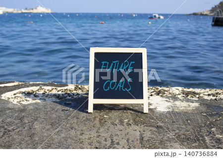 Future Goals symbol. White blackboard with Concept words Future Goals. Beautiful sea background. Business and Future Goals concept. Copy space. Future Goals symbol. White blackboard with Concept words Future Goals. Beautiful sea background. Business and Future Goals concept. Copy space. 140736884