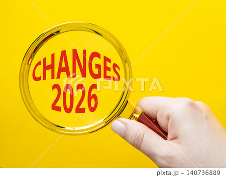 Changes 2026 symbol. Magnifying Glass with words Changes 2026. Beautiful yellow background. Businessman hand. Business and Changes 2026 concept. Copy space. 140736889