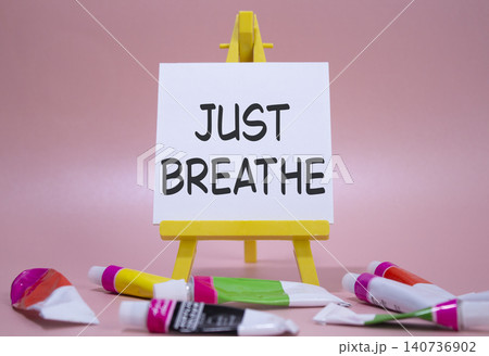 Just Breathe symbol. Wooden blocks with words Just Breathe. Beautiful pink background with paints and easel. Business and Just Breathe concept. Copy space. Just Breathe symbol. Wooden blocks with words Just Breathe. Beautiful pink background with paints and easel. Business and Just Breathe concept. Copy space. 140736902