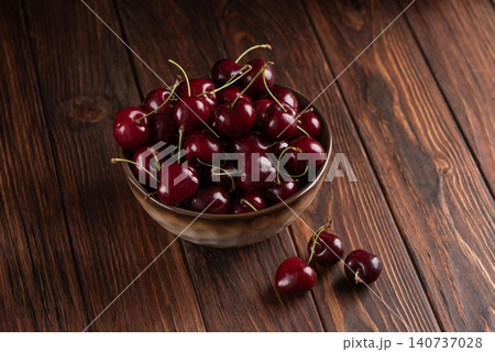 Fresh ripe red cherries in bowl on wooden table Fresh ripe red cherries in bowl on wooden table 140737028