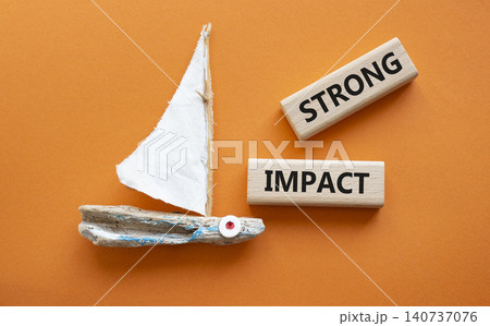 STRONG IMPACT symbol. Concept word STRONG IMPACT on wooden blocks. Beautiful orange background with boat. Business and STRONG IMPACT concept. Copy space STRONG IMPACT symbol. Concept word STRONG IMPACT on wooden blocks. Beautiful orange background with boat. Business and STRONG IMPACT concept. Copy space 140737076