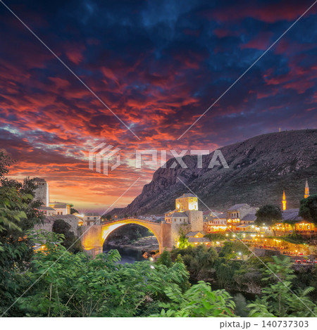 Amazing Skyline of Mostar with the Mostar Bridge, houses and minarets, at sunset. Amazing Skyline of Mostar with the Mostar Bridge, houses and minarets, at sunset. 140737303