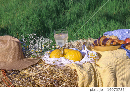 Champagne glass and croissants on straw bale in meadow Champagne glass and croissants on straw bale in meadow 140737854