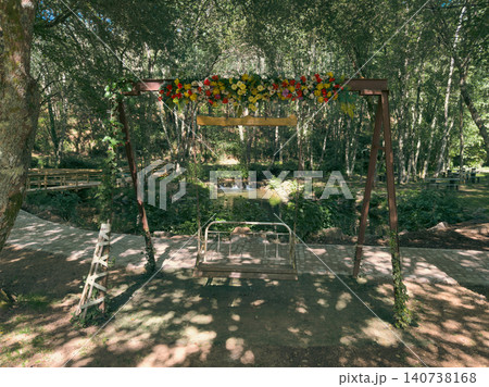 Decorated garden swing at a scenic riverside park in Portugal featuring lush greenery, vibrant floral arrangements, and a peaceful water feature nearby. Decorated garden swing at a scenic riverside park in Portugal featuring lush greenery, vibrant floral arrangements, and a peaceful water feature nearby. 140738168