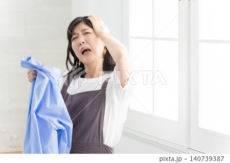 洗濯に失敗して落ち込む女性 洗濯に失敗して落ち込む女性 140739387