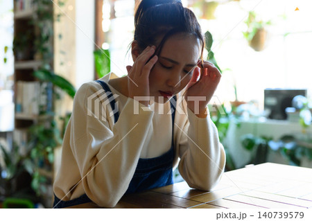 頭を抱えて悩む若い日本人女性 140739579