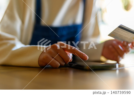 カードを見ながらスマホを操作する手元 カードを見ながらスマホを操作する手元 140739590