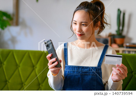 スマホとカードを持つ若い日本人女性 スマホとカードを持つ若い日本人女性 140739594