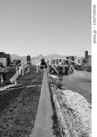2026年 札幌中心部をバックに「水穂大橋」と豊平川 河川敷に伸びるサイクリングロード「白黒」 2026年 札幌中心部をバックに「水穂大橋」と豊平川 河川敷に伸びるサイクリングロード「白黒」 140739846
