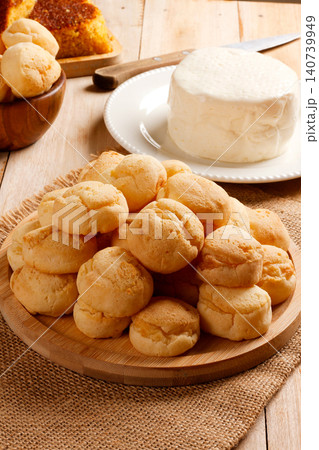 Homemade cheese bread, fresh cheese, and cornbread on a wooden surface in a cozy setting. 140739949