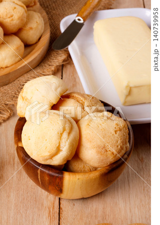 Cheese bread served in rustic containers, accompanied by black coffee and butter, creating a homemade meal atmosphere Cheese bread served in rustic containers, accompanied by black coffee and butter, creating a homemade meal atmosphere 140739958