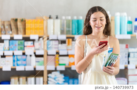 Young woman scanning a package with a toothbrush Young woman scanning a package with a toothbrush 140739973