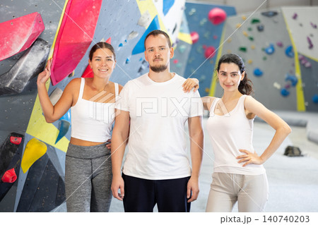 Portrait of three athletic people in climbing gym Portrait of three athletic people in climbing gym 140740203