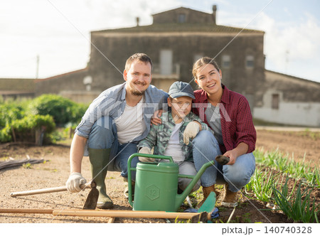 Man woman and boy planting seeds in field Man woman and boy planting seeds in field 140740328