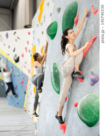 Young woman doing rock climbing on climbing wall Young woman doing rock climbing on climbing wall 140740330