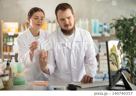 Two pharmacists working at a computer Two pharmacists working at a computer 140740357