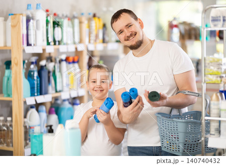 Schoolboy son and dad are choosing trash bags in store Schoolboy son and dad are choosing trash bags in store 140740432