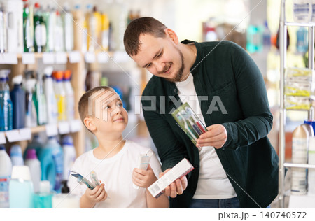 Man and boy choosing toothbrush in store Man and boy choosing toothbrush in store 140740572