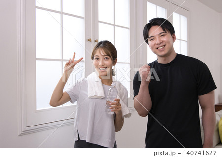 パーソナルトレーナーと会話する笑顔の若い女性 パーソナルトレーナーと会話する笑顔の若い女性 140741627