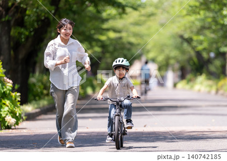 自転車の練習をする男の子と見守る母親 自転車の練習をする男の子と見守る母親 140742185