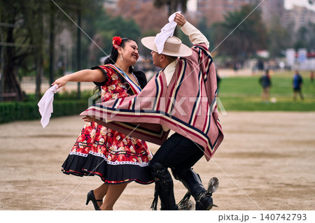 A pair of young Chilean Latin dancers dancing cuecas, the Chilean national dance, in a very cheerful, charismatic, and romantic manner. Chilean Independence Day A pair of young Chilean Latin dancers dancing cuecas, the Chilean national dance, in a very cheerful, charismatic, and romantic manner. Chilean Independence Day 140742793