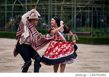 A pair of young Chilean Latin dancers dancing cuecas, the Chilean national dance, in a very cheerful, charismatic, and romantic manner. Chilean Independence Day A pair of young Chilean Latin dancers dancing cuecas, the Chilean national dance, in a very cheerful, charismatic, and romantic manner. Chilean Independence Day 140742802