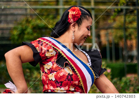 Portrait of a beautiful young woman smiling, cheerfully dressed as a Chilean huasa, joyfully celebrating and posing to dance the cueca, a traditional Chilean dance. Chilean traditions. 140742803